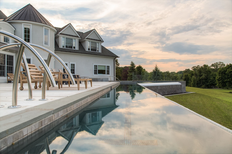 Infinity swimming pool by a luxury house, showcasing modern swimming pool designs