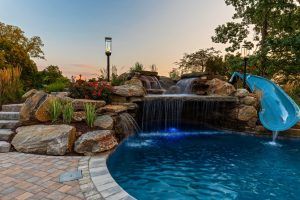 Inground pool with waterfall, hot tub and slide.