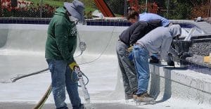 Team adding plaster to pool