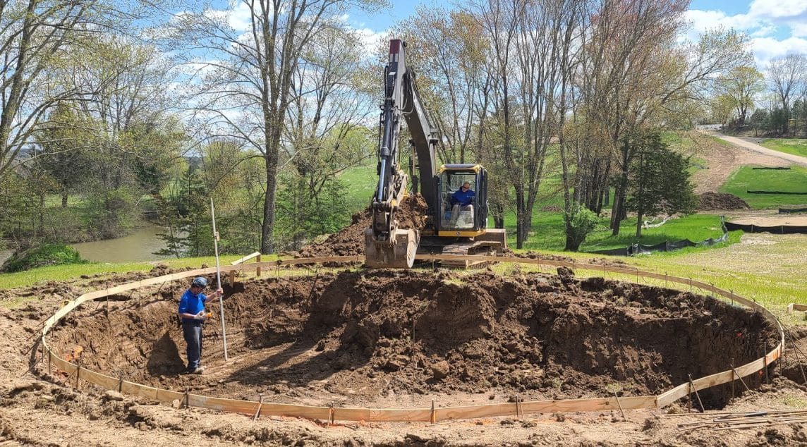 Contruction Worker in Hole With Excavator Equipment