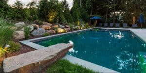 Inground pool surrounded by stone landscape