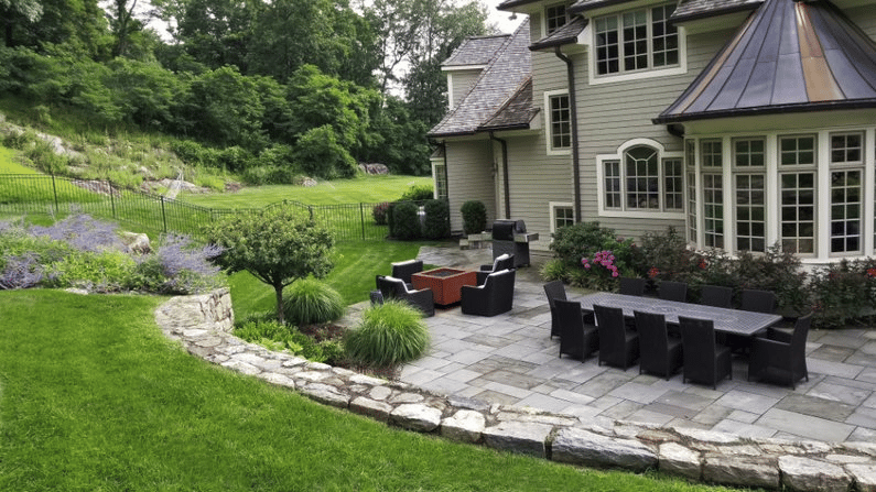 Beige home with backyard stone patio and seating