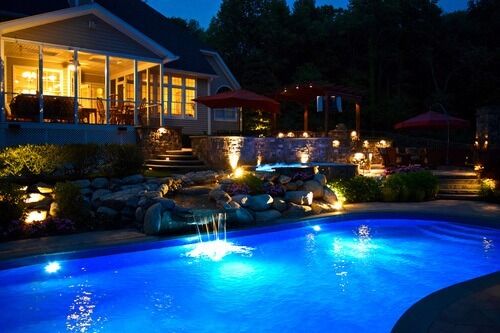 Process of adding lighting to a landscape design for a pool, living walls, and on deck building