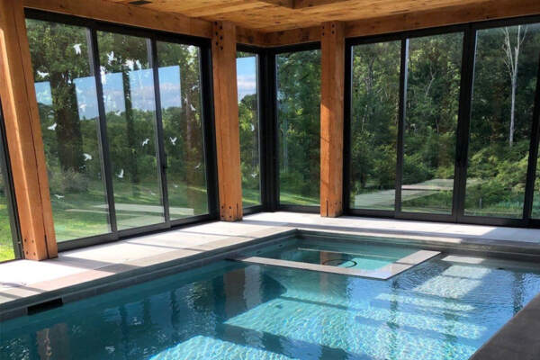 Luxury indoor swimming pool with view surrounded by nature